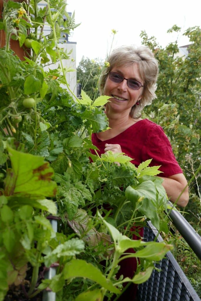 Die strahlende Balkonbotschafterin Birgit Schattling, so ernannt von Natur im Garten International, steht vor ihrem Vertikalbeet.