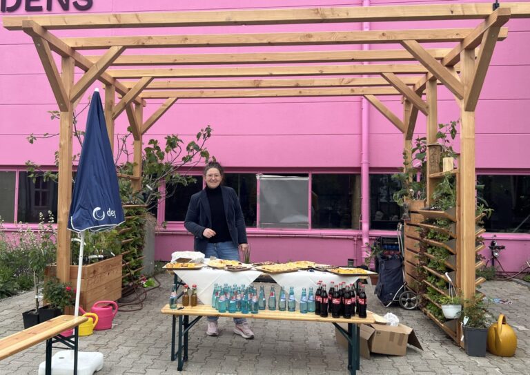 Die Klimaterrasse mit Vertikalbeet und Trog in der Balkonschule Berlin. Die ersten Mieter nutzen die Klimaterrasse als Unterstand fürs Buffet.